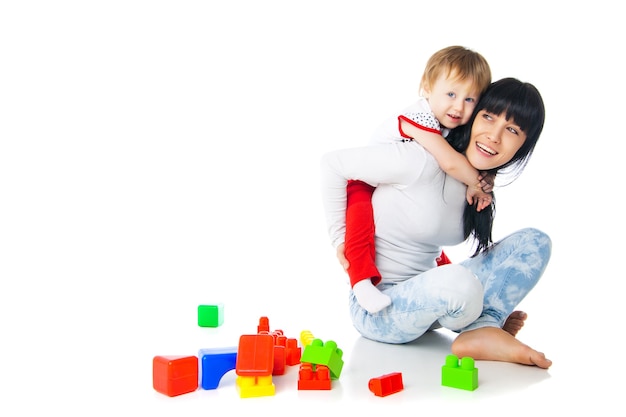 La madre y el bebé jugando con juguetes de bloques de construcción