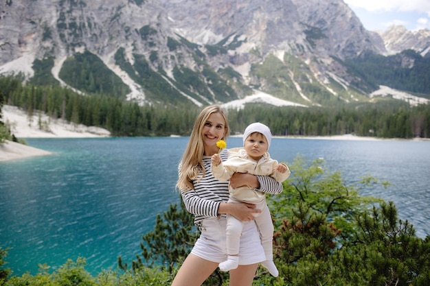 Madre y bebé en el lago de montaña en un día soleado Madre sosteniendo al bebé foto de alta calidad