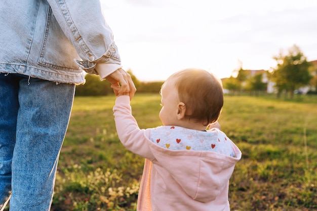 Madre con un bebé mamá enseña al bebé a caminar