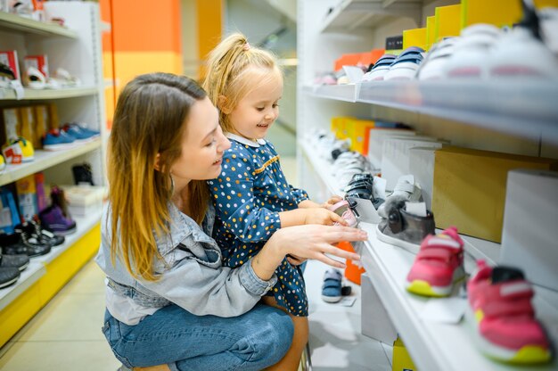 Madre y bebé mirando zapatos en la tienda del niño