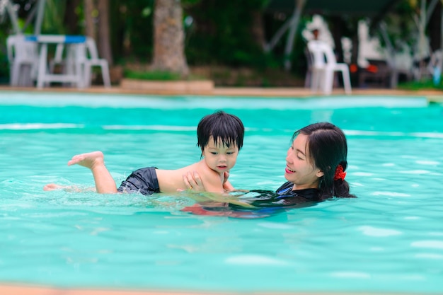 Madre y bebé nadan en la piscina