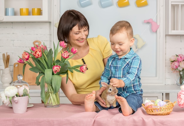 Madre y bebé en la Pascua decorada cocina pastel.