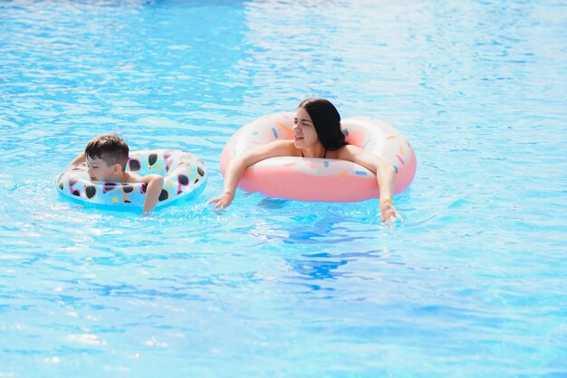 Madre y bebé en la piscina al aire libre del resort tropical.