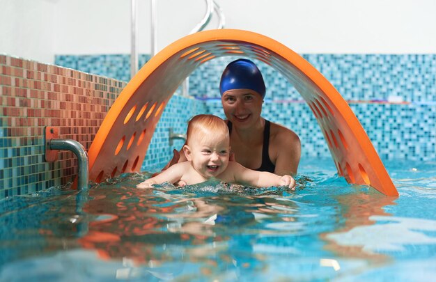 Madre con bebé en piscina entrenando