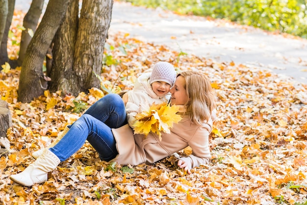 Madre y bebé relajándose en el parque otoño