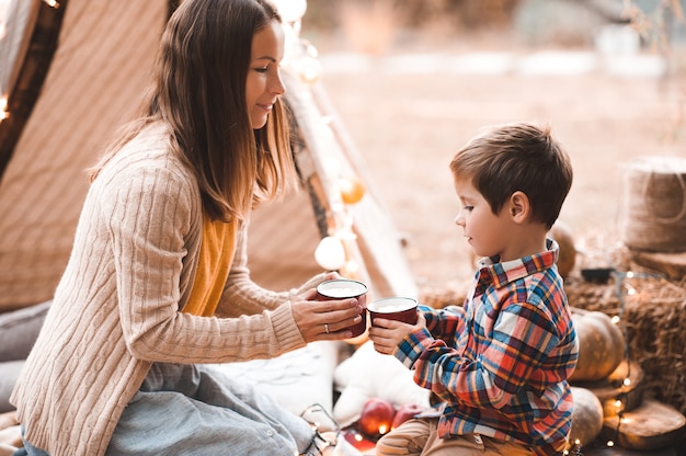 Madre bebiendo té con niño hijo al aire libre