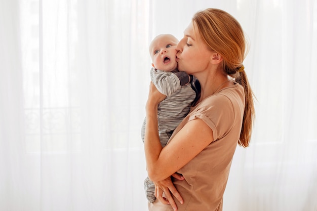 Madre besando y abrazando bebe