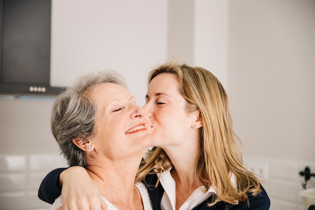 Foto madre besando hija en el día de la madre