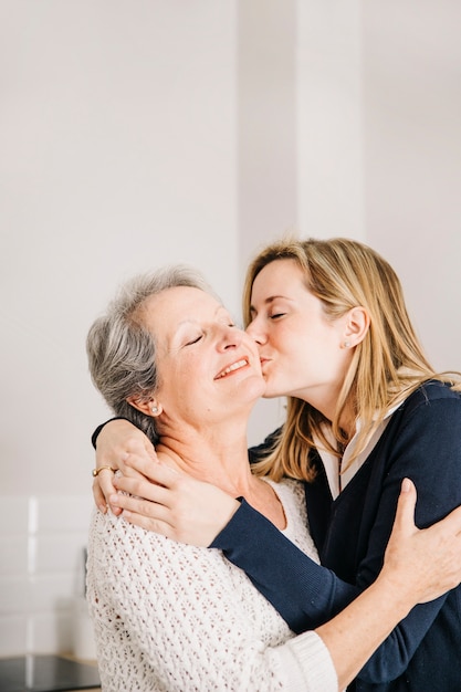 Foto madre besando hija en el día de la madre