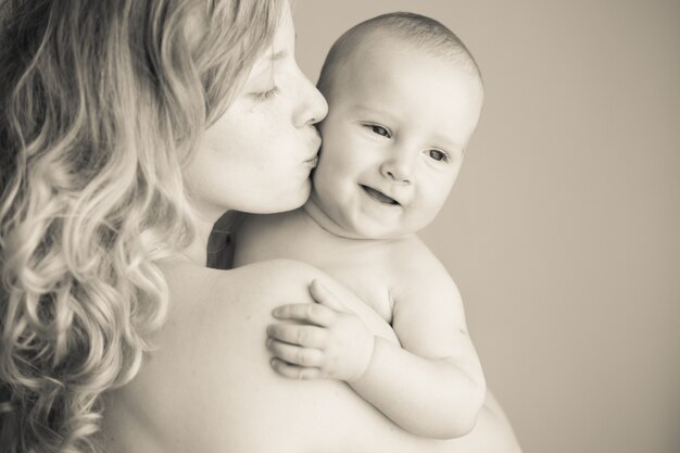 Madre besando a su bebé, retratos de cerca