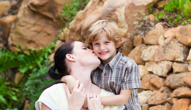 Madre besando a su hijo en un parque