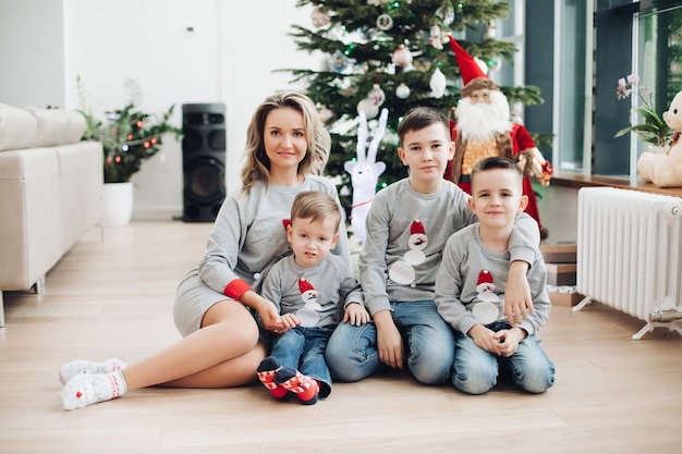 Madre bonita con tres hijos en suéter