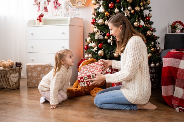 Madre con cajas de regalo y su pequeña hija