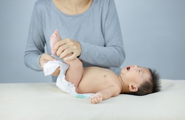 Madre cambiando un pañal a un bebé