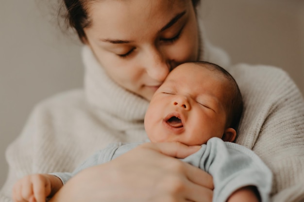 Madre cariñosa que cuida a su bebé recién nacido en casa Primer plano retrato de un niño feliz durmiendo en las manos Madre abrazando a su pequeña hija de 1 mes