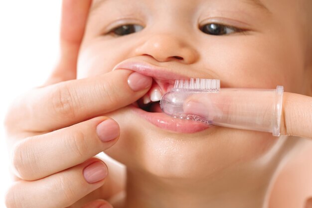 Madre cepillando suavemente sus pequeños dientes de niño