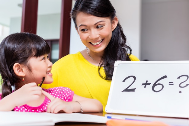 Madre china enseñando matemáticas al niño