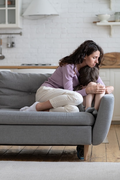 Madre consoladora llorando deprimido hijo después de la disputa familiar madre solícita comodidad destacó niño pequeño