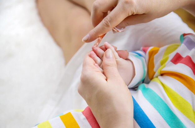 Madre corta las uñas del bebé Enfoque selectivo