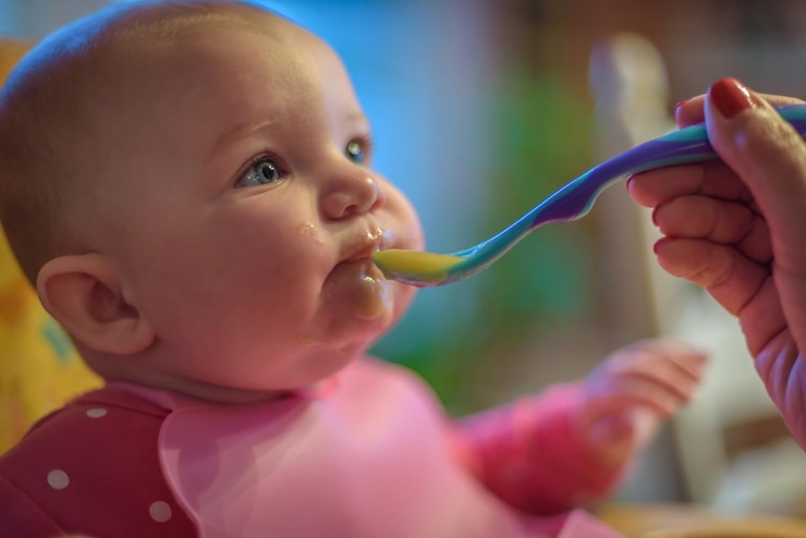 Foto madre cortada alimentando a su bebé en casa