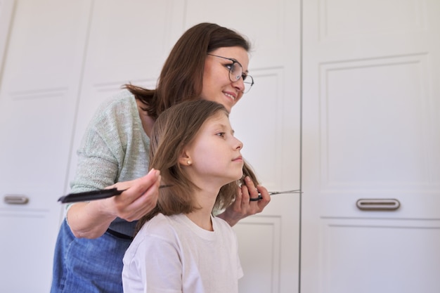 Madre cortando cabello a hija en casa, niños, peinados, cabello, belleza.