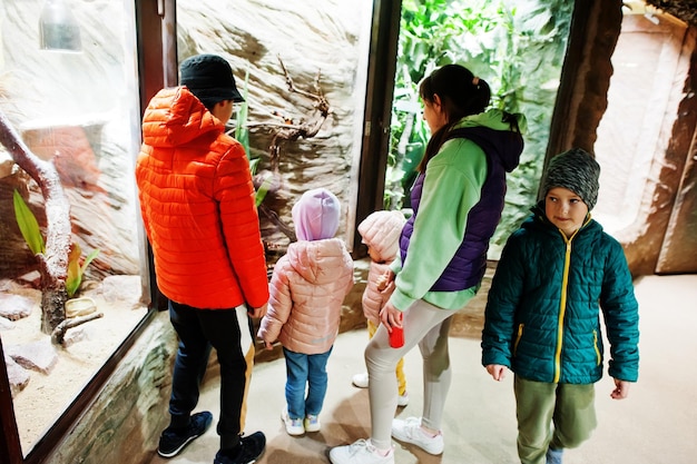 Madre con cuatro hijos descubriendo y observando animales en el zoológico