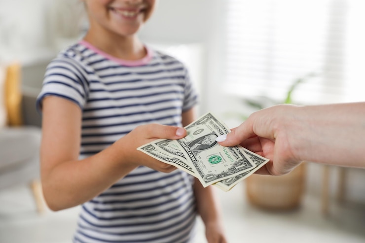 Foto madre dando dinero de bolsillo a su hija en casa de cerca