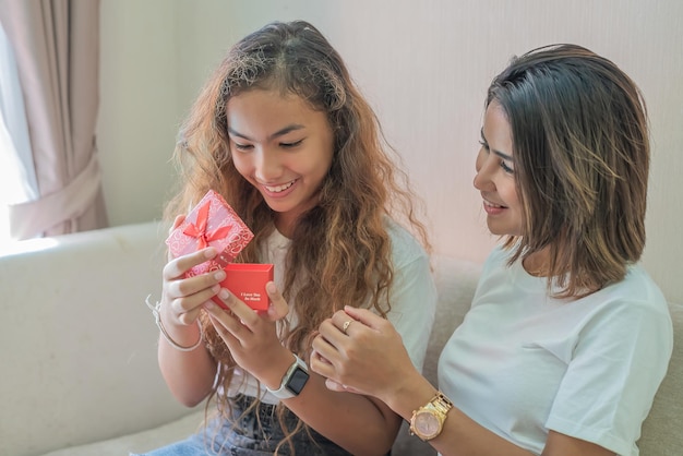 Madre dando hija regalo de cumpleaños