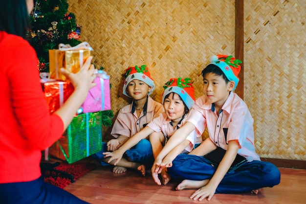 Madre dando regalos a los niños en el festival de navidad.