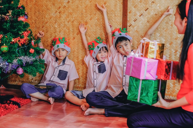 Madre dando regalos a los niños en el festival de navidad.