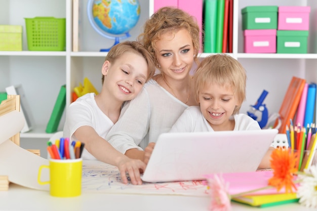 Madre dibujando con tres lindos hijos.