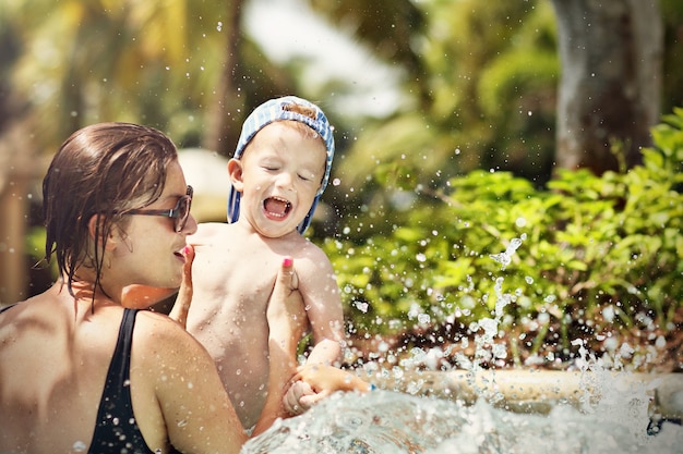 madre divirtiéndose en la playa con su pequeño hijo