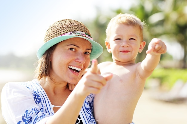 madre divirtiéndose en la playa con su pequeño hijo