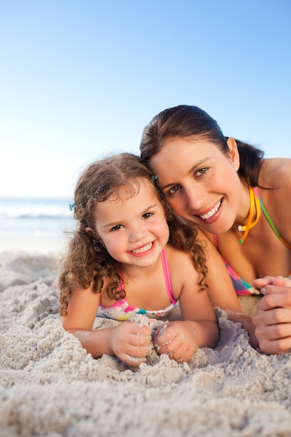 Madre e hija acostada en la playa