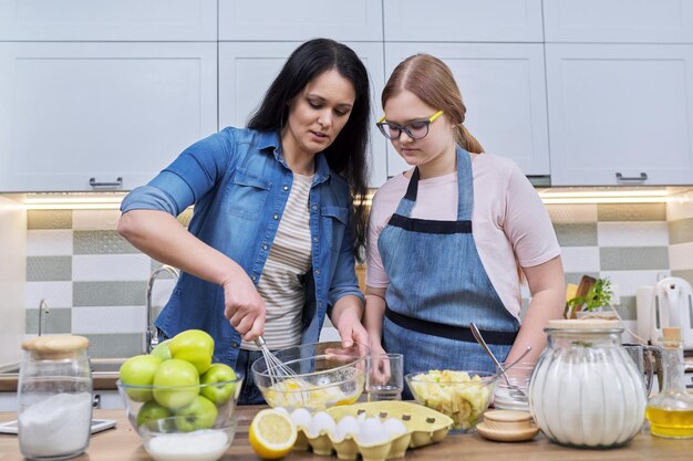 Madre e hija adolescente cocinando en casa en la cocina