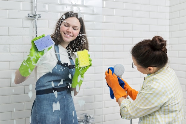 Madre e hija adolescente limpiando juntos en el baño. Niña ayudando a la madre a limpiar en casa. Adolescentes y padres, relaciones, limpieza y limpieza, tareas del hogar