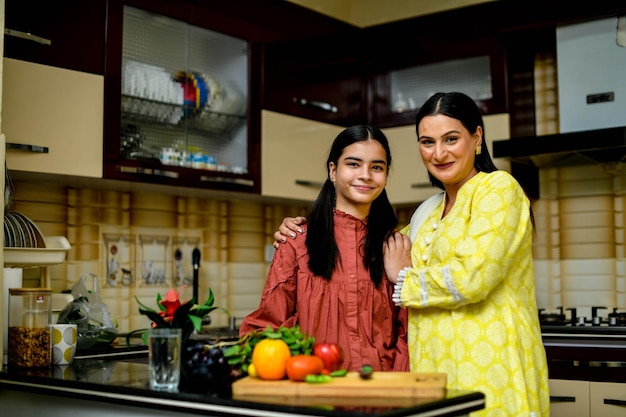 madre e hija adorable están en la cocina modelo paquistaní indio