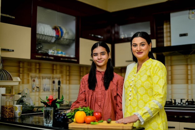 madre e hija adorable están en la cocina modelo paquistaní indio