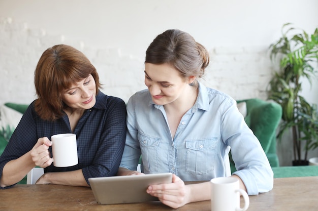 Madre e hija adulta usando una tableta en casa