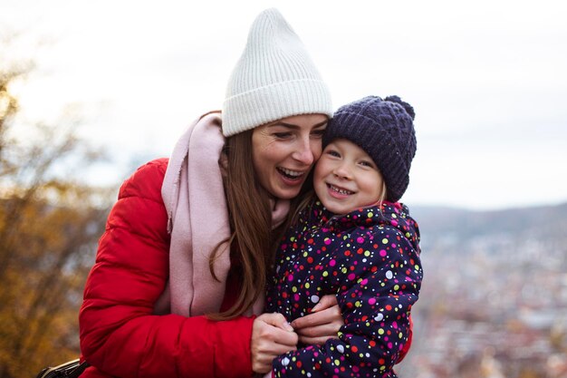 Madre e hija alegres abrazándose contra el telón de fondo de una vista panorámica