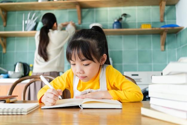 Madre e hija asiáticas estudiando juntas en casa