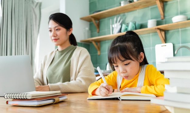 Madre e hija asiáticas estudiando juntas en casa