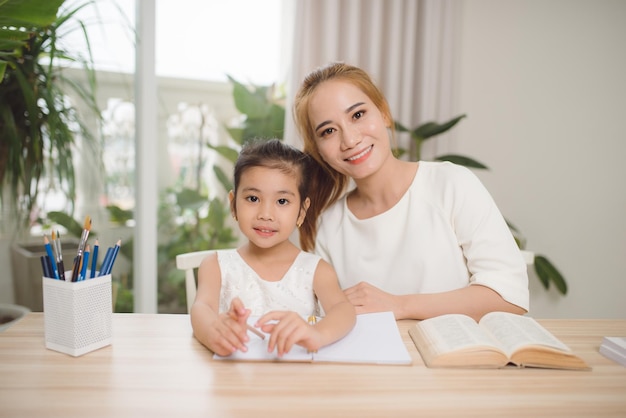 Madre e hija asiáticas haciendo trabajo doméstico juntos en la sala de estar