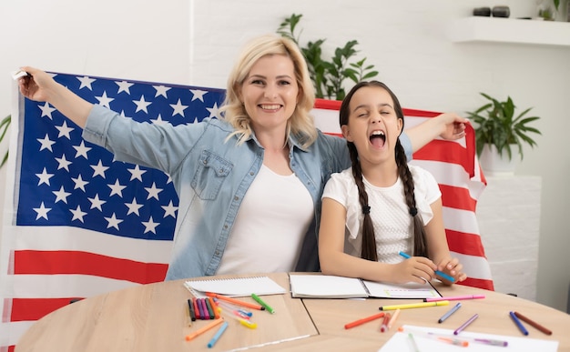 Foto madre e hija con bandera estadounidense.