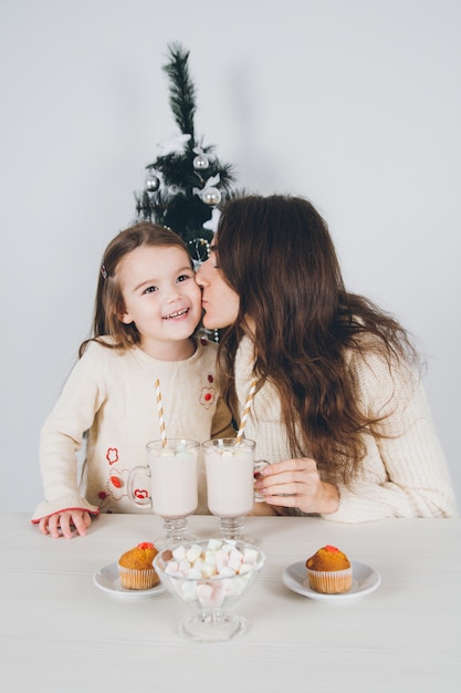 Madre e hija beben chocolate con malvaviscos