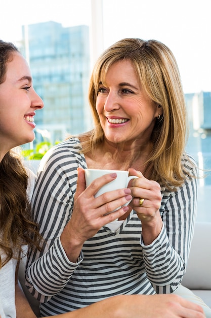 Madre e hija beben té en la cocina