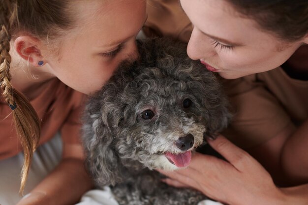 madre e hija besando perro