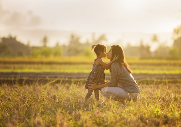 Madre e hija besándose en el campo