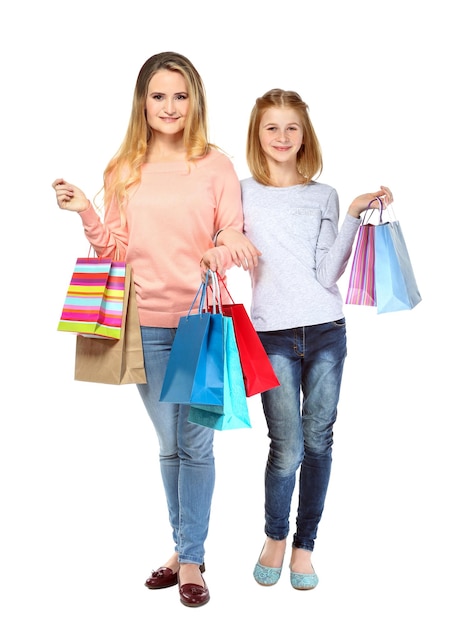Madre e hija con bolsas de papel sobre fondo blanco.