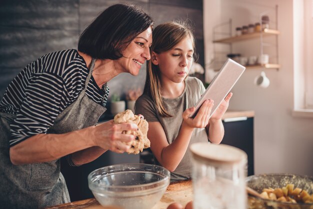 Madre e hija buscando receta de pastel de manzana en la tableta